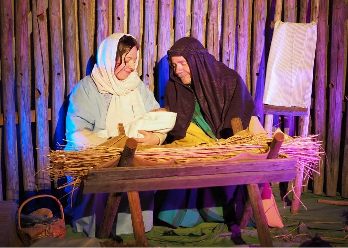 Maria, Joosef ja Jeesus-vauva seimen luona.