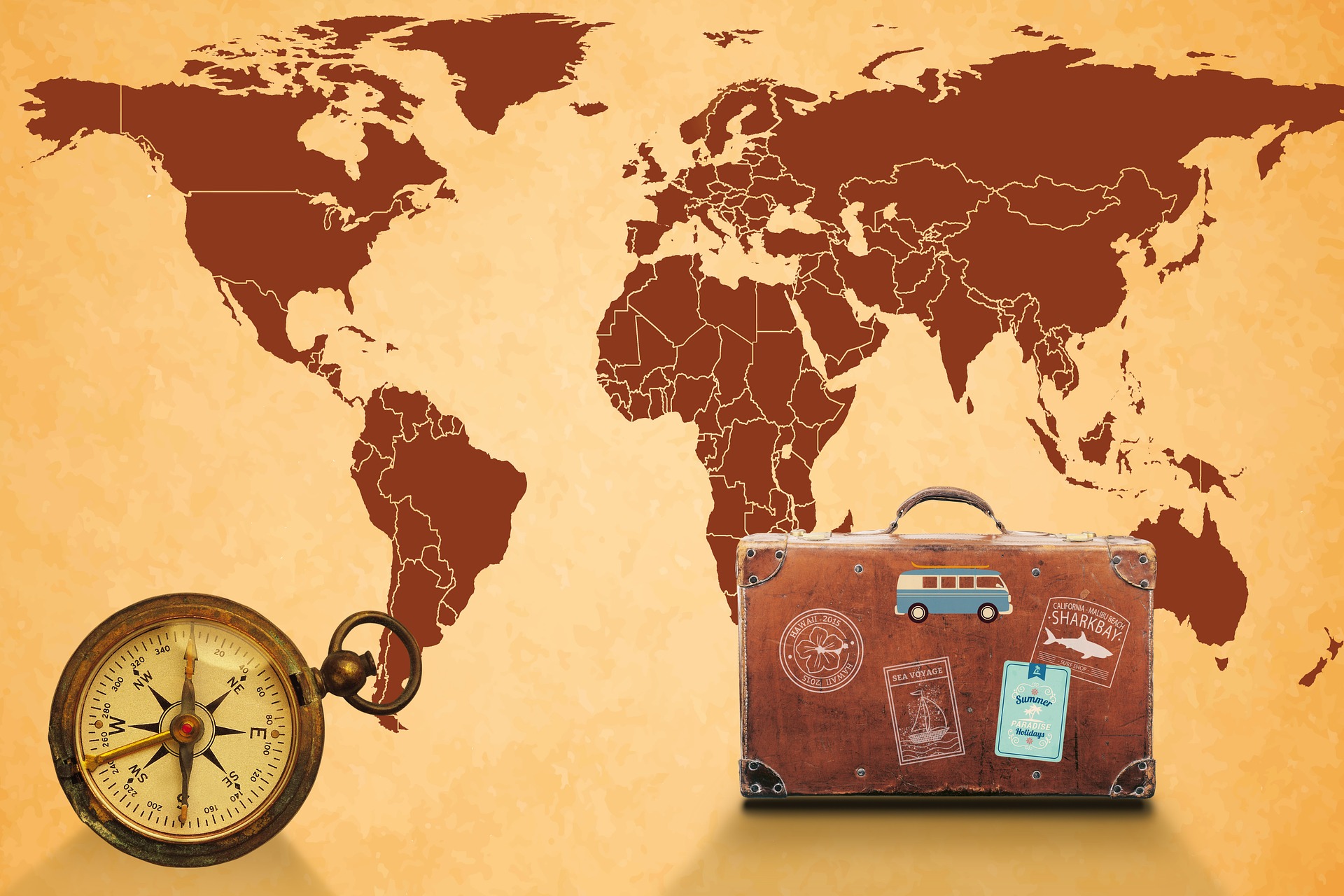 Maailmankartta, matkalaukku ja kompassi.