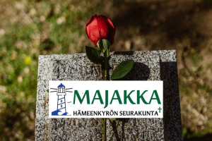 Punainen ruusu kiven päällä ja Majakan logo.