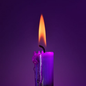 Violetti palava kynttilä violetilla taustalla.