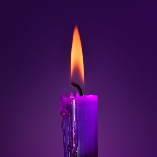 Messu Violetti palava kynttilä violetilla taustalla.