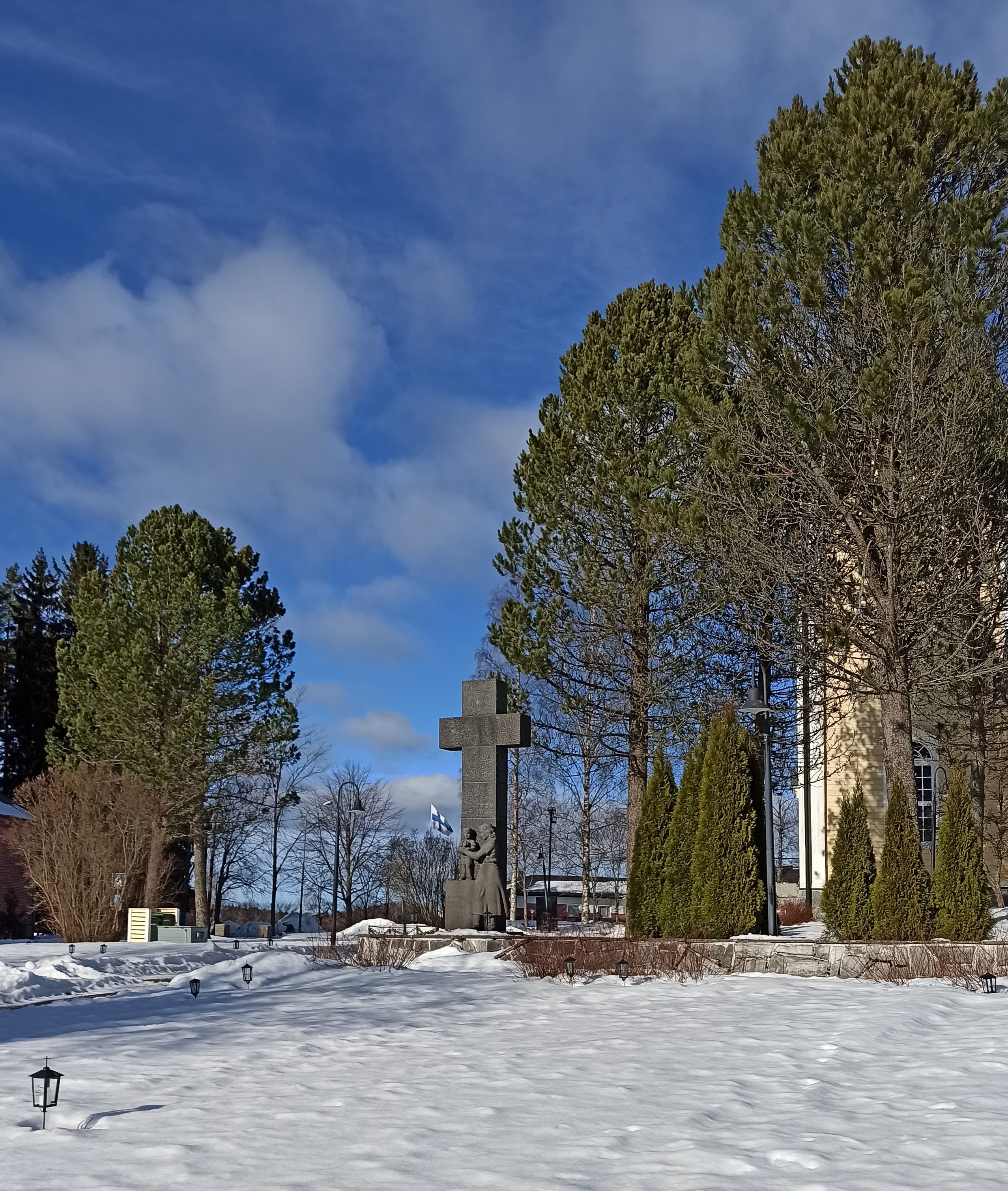 Kuvassa Hämeenkyrön sankarihautausmaa sekä sankaripatsas. Taustalla liehuu Suomen lippu.