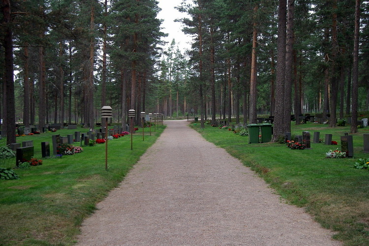 Mäntyrinteen hautausmaan pääkäytävä, jonka molemmilla puolilla on hautoja.
