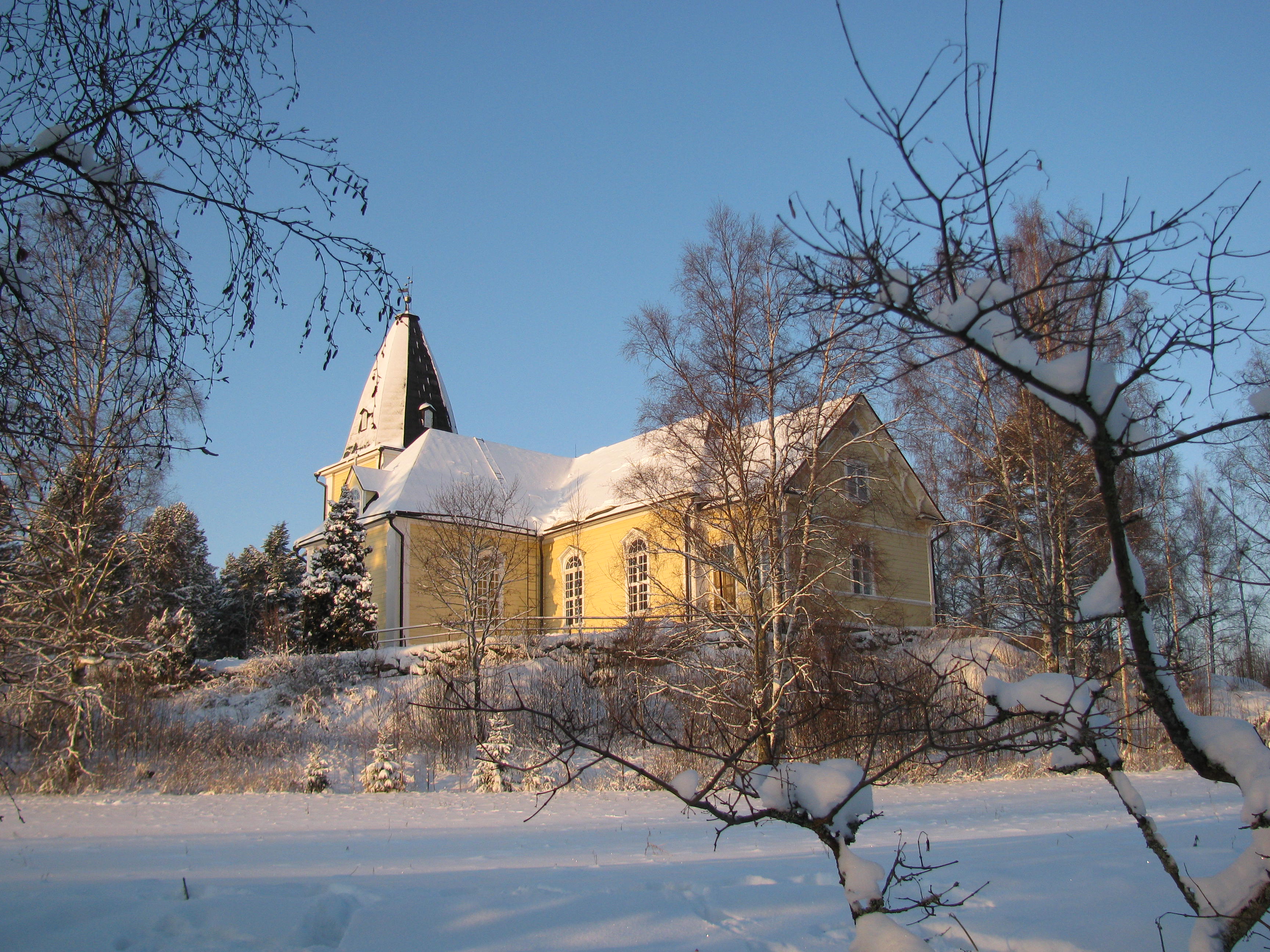 Hämeenkyrön kirkko lumisen maiseman keskellä.