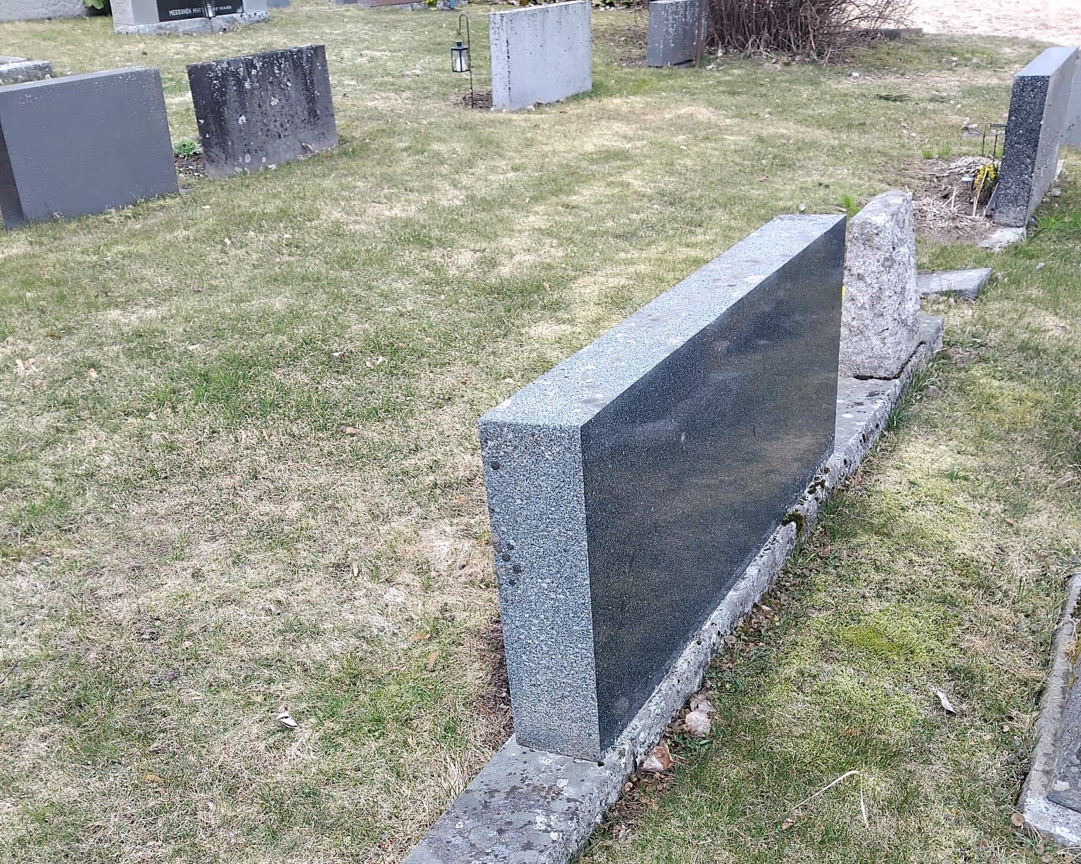 kallistunut harmaa hautakivi.