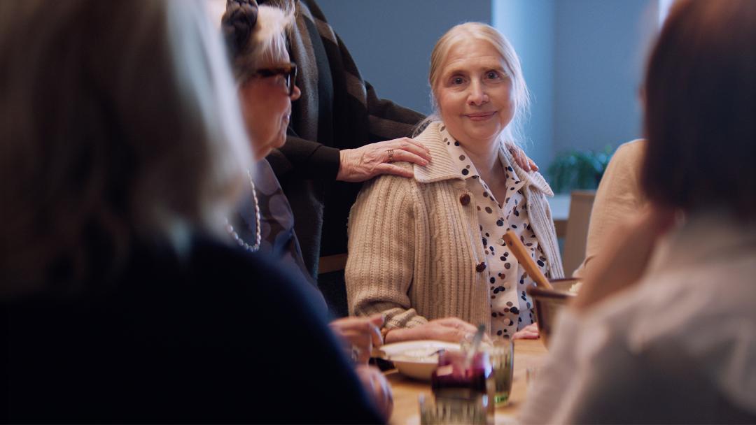 nainen istuu ruokapöydässä